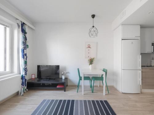 eine Küche und ein Esszimmer mit einem Tisch und Stühlen in der Unterkunft Kotimaailma Apartments Joensuu - Kalevankatu 36 in Joensuu