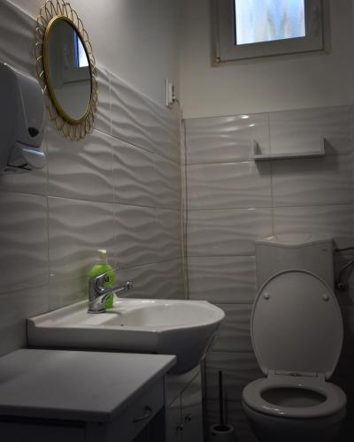 a bathroom with a sink and a toilet and a mirror at Pellegrini Apartman in Balatonakali