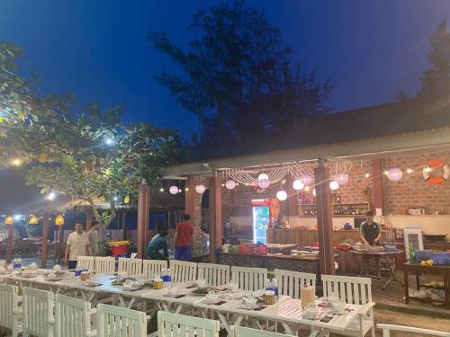 ドンホイにあるNana Lee Homestay & Restaurant Quảng Bìnhの夜のレストラン前の長いテーブル