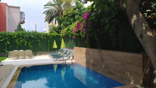 a swimming pool in a yard with chairs and flowers at Meyde Boutique Suites in Antalya