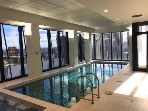 a swimming pool in a building with windows at Winston Apartments in Melbourne