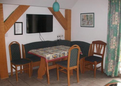a dining room with a table and chairs and a tv at Ferienhof Rustemeier in Altenberge