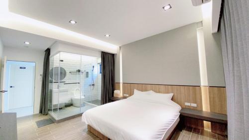 1 dormitorio con cama blanca y baño en Kimen Yuyu B&B, en Jinning