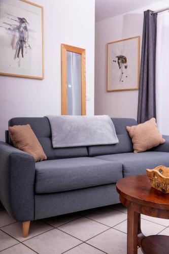 a blue couch in a living room with a mirror at Hôtel Restaurant Domaine De Basil in Orbey