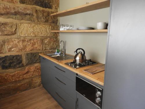 uma cozinha com uma chaleira de chá e um fogão em Oranje Guest Farm em Fouriesburg