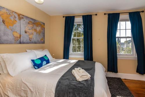 um quarto com uma cama grande e cortinas azuis em 915CountyLineRoad Luxury Mainline Train Colleges em Bryn Mawr
