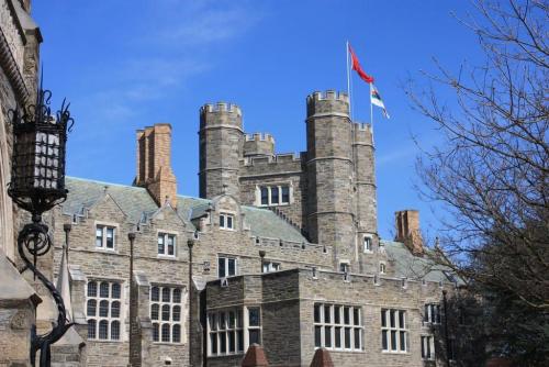 an old castle with a flag on top of it at 915CountyLineRoad Luxury Mainline Train Colleges in Bryn Mawr