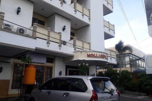 a silver car parked in front of a building at RedDoorz Brand MAN12045 RedDoorz near Megamall Manado in Manado