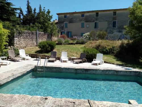 une piscine avec des chaises et un bâtiment en arrière-plan dans l'établissement Mas de 