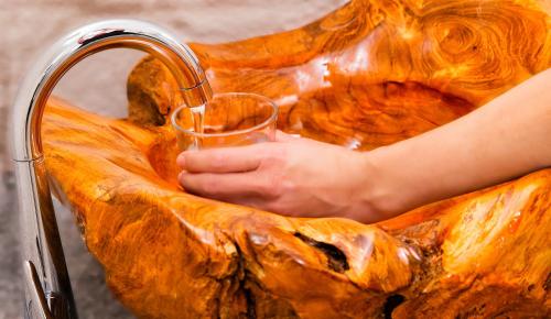 a person is holding a glass in a sink at Hotel Vaduzerhof by b-smart in Vaduz