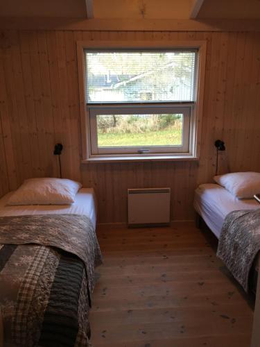 two beds in a room with a window at Nordboferie - Tranevænget 8 Hulsig in Skagen