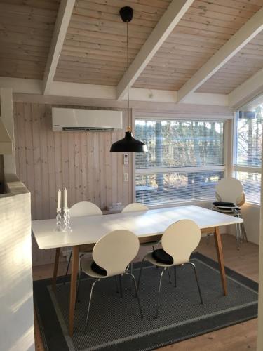 un comedor con una gran mesa blanca y sillas en Nordboferie - Tranevænget 8 Hulsig, en Skagen