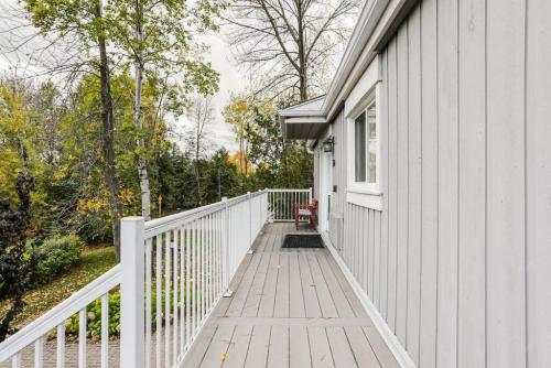 a white house with a white fence and a wooden porch at Cozy Collingwood Retreat 80204 in Collingwood