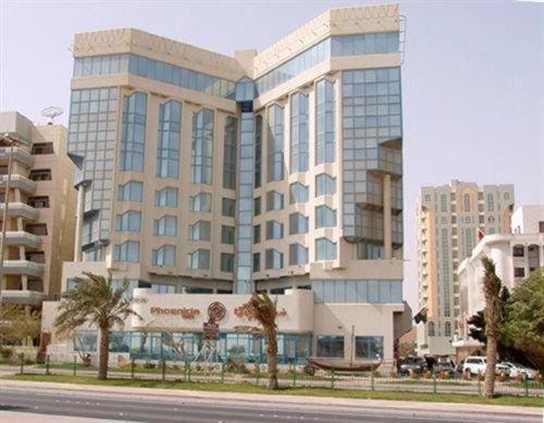 マナーマにあるPhoenicia Tower Hotel And Spaのヤシの木が目の前に広いオフィスビル