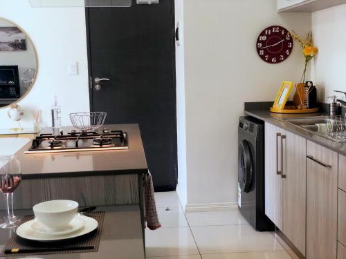 a kitchen with a stove top oven next to a sink at Mikey's place with Fibre Uncapped WiFi in Midrand