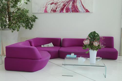 a purple couch in a living room with a table at Smeraldo Suites & Spa in San Benedetto del Tronto