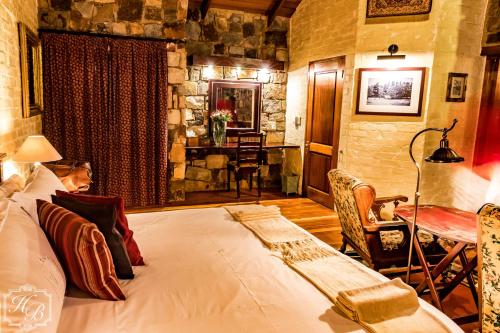 1 dormitorio con 1 cama y 1 mesa en una habitación en Heysbrook Estate - Luxurious lodges in a private valley, en Waterval-Onder