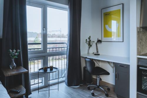 a bedroom with a desk and a window with a view at Magnolia House Norrviken in Sollentuna