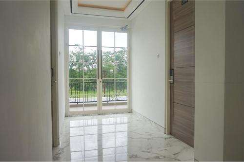 a hallway with a large window and a door at RedDoorz near Araya Family Club House in Malang