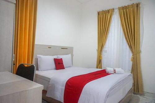 Tempat tidur dalam kamar di RedDoorz near Araya Family Club House