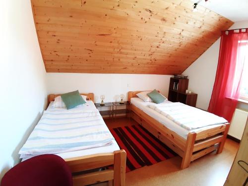 2 camas en una habitación con techo de madera en Ferienwohnungen Leffer en Großheirath