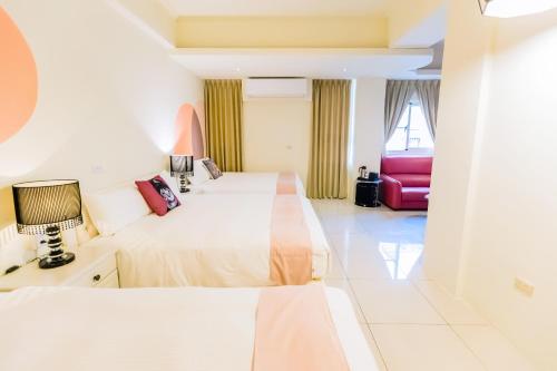 a hotel room with two beds and a window at 湯園民宿 l 民宿編號1639 in Taitung City