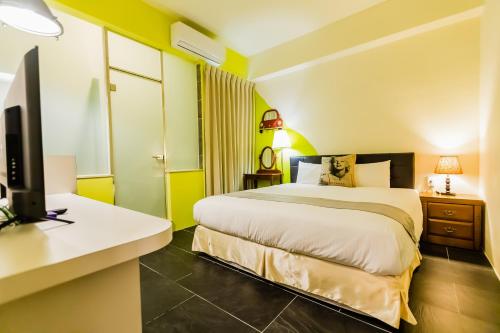 a bedroom with a bed and a desk with a computer at 湯園民宿 l 民宿編號1639 in Taitung City