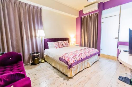 a purple bedroom with a bed and a chair at 湯園民宿 l 民宿編號1639 in Taitung City