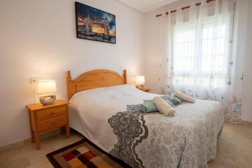Un dormitorio con una cama y dos lámparas y una ventana. en Spacious Ground floor apartment with Garden & Communal Pool, en Los Dolses