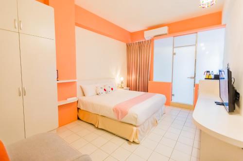 a hotel room with a bed and a tv at 湯園民宿 l 民宿編號1639 in Taitung City