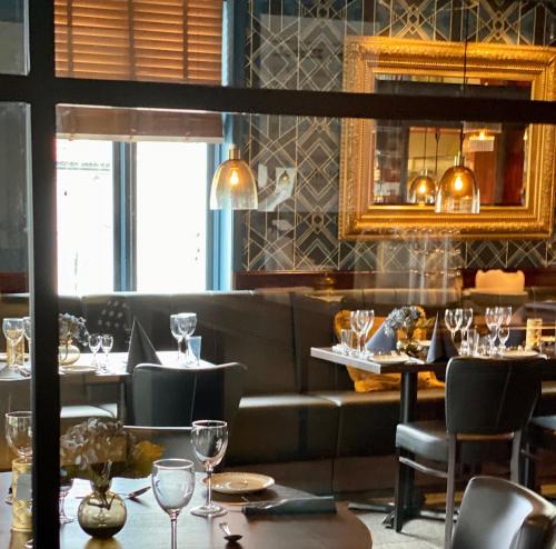 a restaurant with tables and chairs and a mirror at Reenskaug Hotel in Drøbak