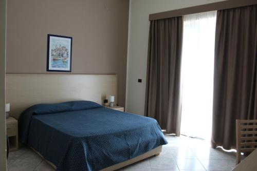 a bedroom with a bed and a window at Hotel Tourist in Cefalù