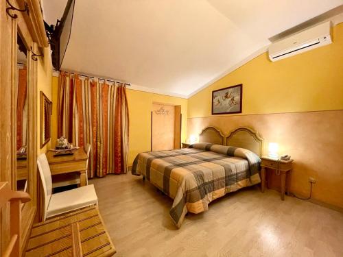 1 dormitorio con 1 cama, 1 mesa y 1 silla en Hotel Berti, en Asís