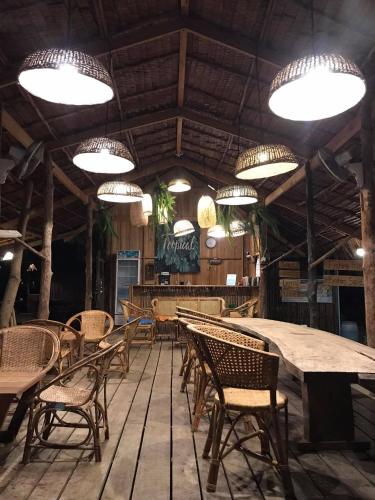 a dining room with tables and chairs and lights at The Tropical Koh Mook in Koh Mook