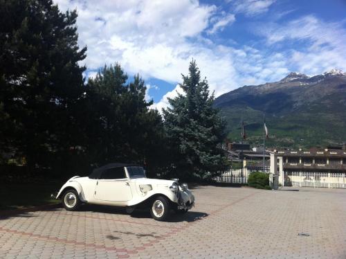 a white car parked in a parking lot at Hotel Miage in Aosta