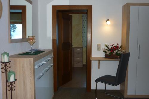 a kitchen with a wine glass on a counter and a chair at Kreidl in Tux