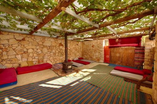 um quarto com um grupo de camas e uma lareira em Back to Nature Camping & Huts em Mikhmannim