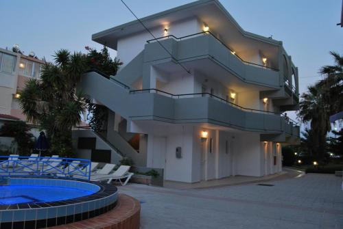 a large building with a staircase and a swimming pool at Artemis Studios in Faliraki