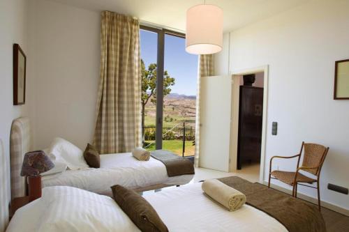 two beds in a room with a window at GreenSide 38 by VillaGranCanaria in San Bartolomé de Tirajana