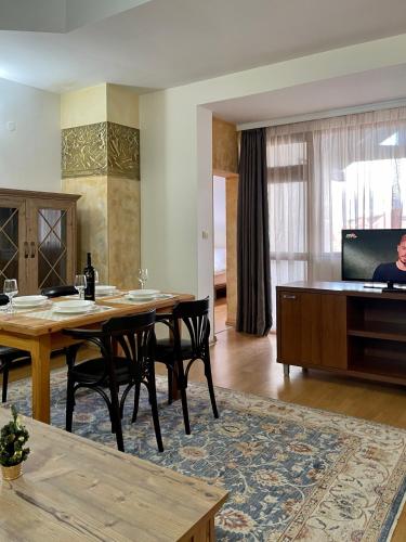 a living room with a table and a piano at Dolomiti Apartments in Bansko