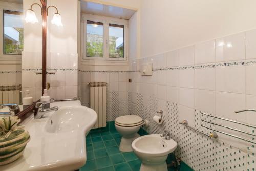 ein weißes Bad mit einem WC und einem Waschbecken in der Unterkunft San Pietro Cozy Apartment with Terrace! in Rom