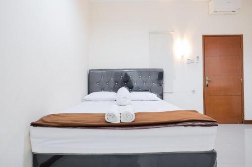 Tempat tidur dalam kamar di wisma delapan Mitra RedDoorz