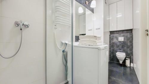 a white bathroom with a shower and a toilet at Dwie Sosny z sauną, Sun & Snow in Ustronie Morskie