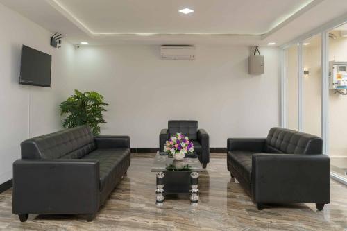 a lobby with two couches and a table with flowers at RedDoorz Plus near Eka Hospital BSD 5 in Tangerang