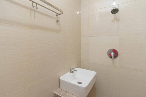 a white bathroom with a sink and a shower at RedDoorz Plus near Eka Hospital BSD 5 in Tangerang