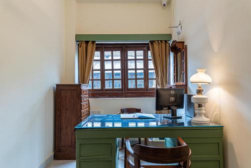 a room with a desk with a computer and a window at Casa Dos Rebelos in Panaji