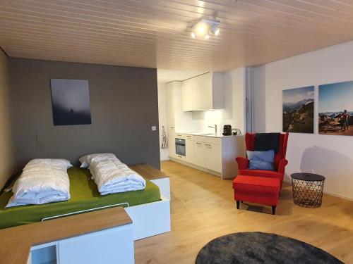 a bedroom with a bed and a red chair at Zentrum Lai 176 Hm Whg 103 Steibogg in Lenzerheide