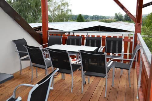 a deck with a table and chairs on a roof at Penzion Sedlecká vína in Sedlec