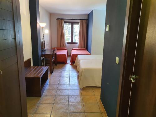 a hotel room with a bed and a table and chairs at HOTEL MASIA EL MOLINETE in Mora de Rubielos