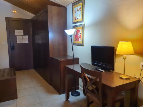 a room with a desk with a computer and a lamp at HOTEL MASIA EL MOLINETE in Mora de Rubielos